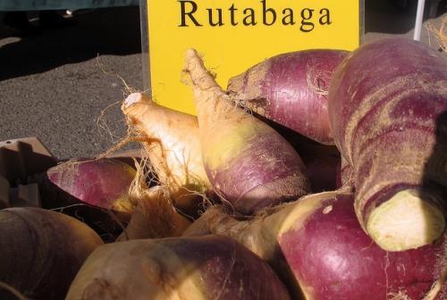Rutabaga pile in front of a yellow "Rutabaga" sign