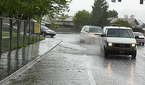 cars driving through standing water on a road