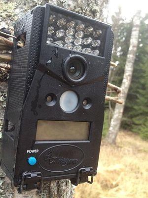 A remote camera mounted on a post outdoors.