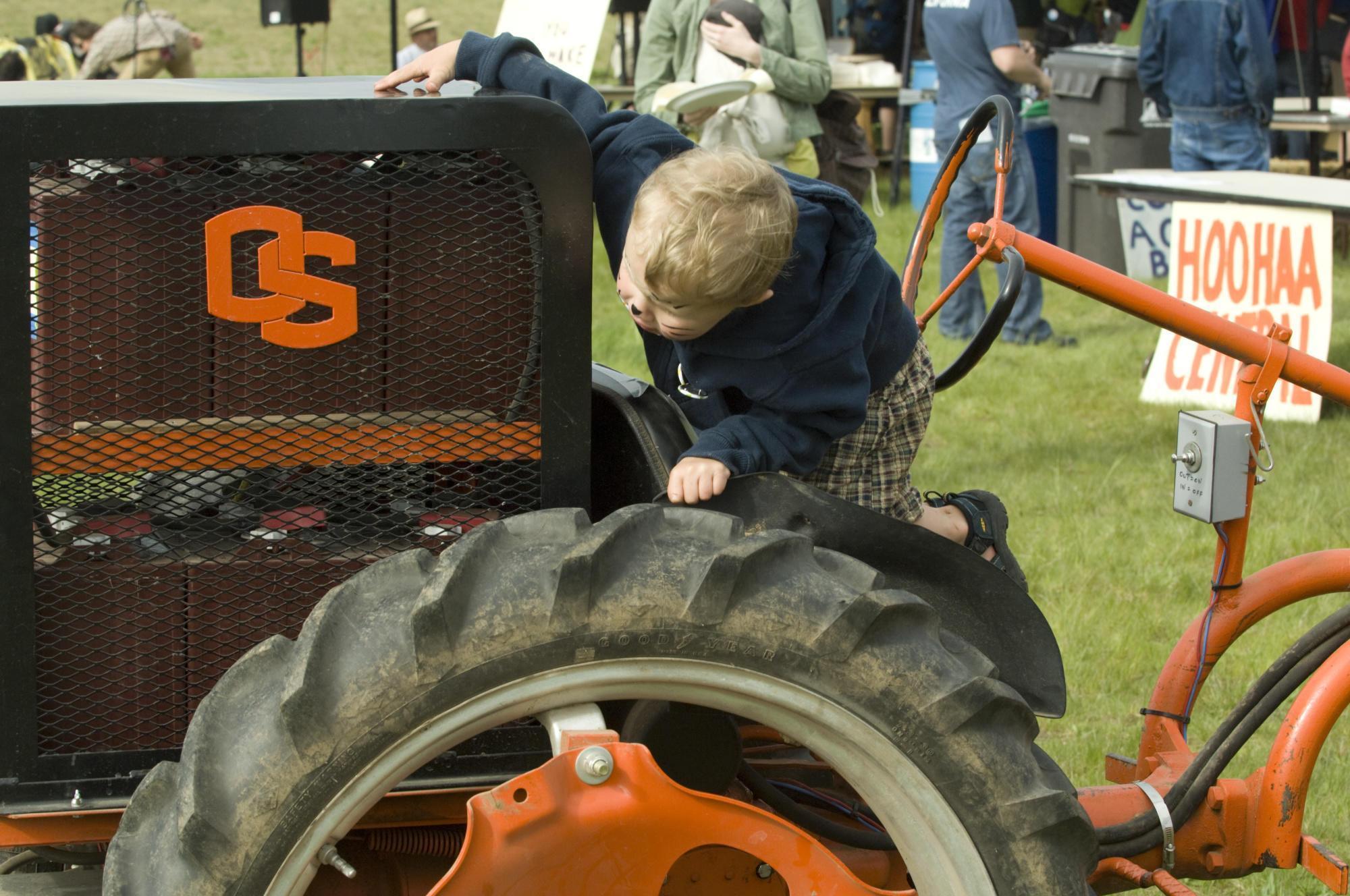Child climbing on an OSU tractor