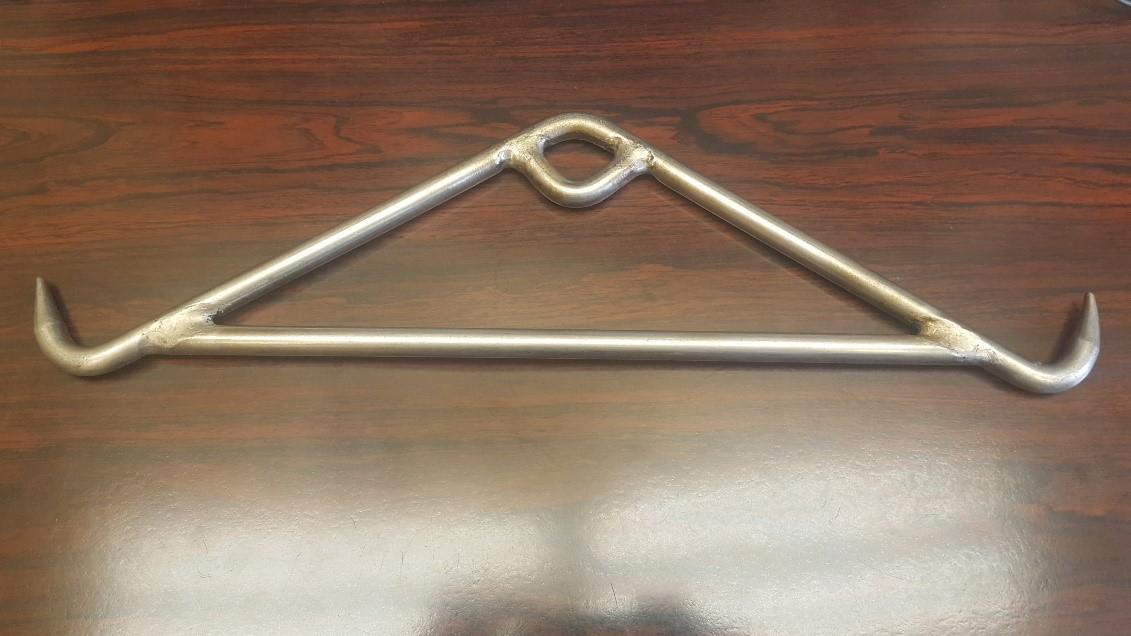 A gambrel is a metal hanger-like device with hooks on each end to attach to a carcass to allow it to be hoisted off the ground.