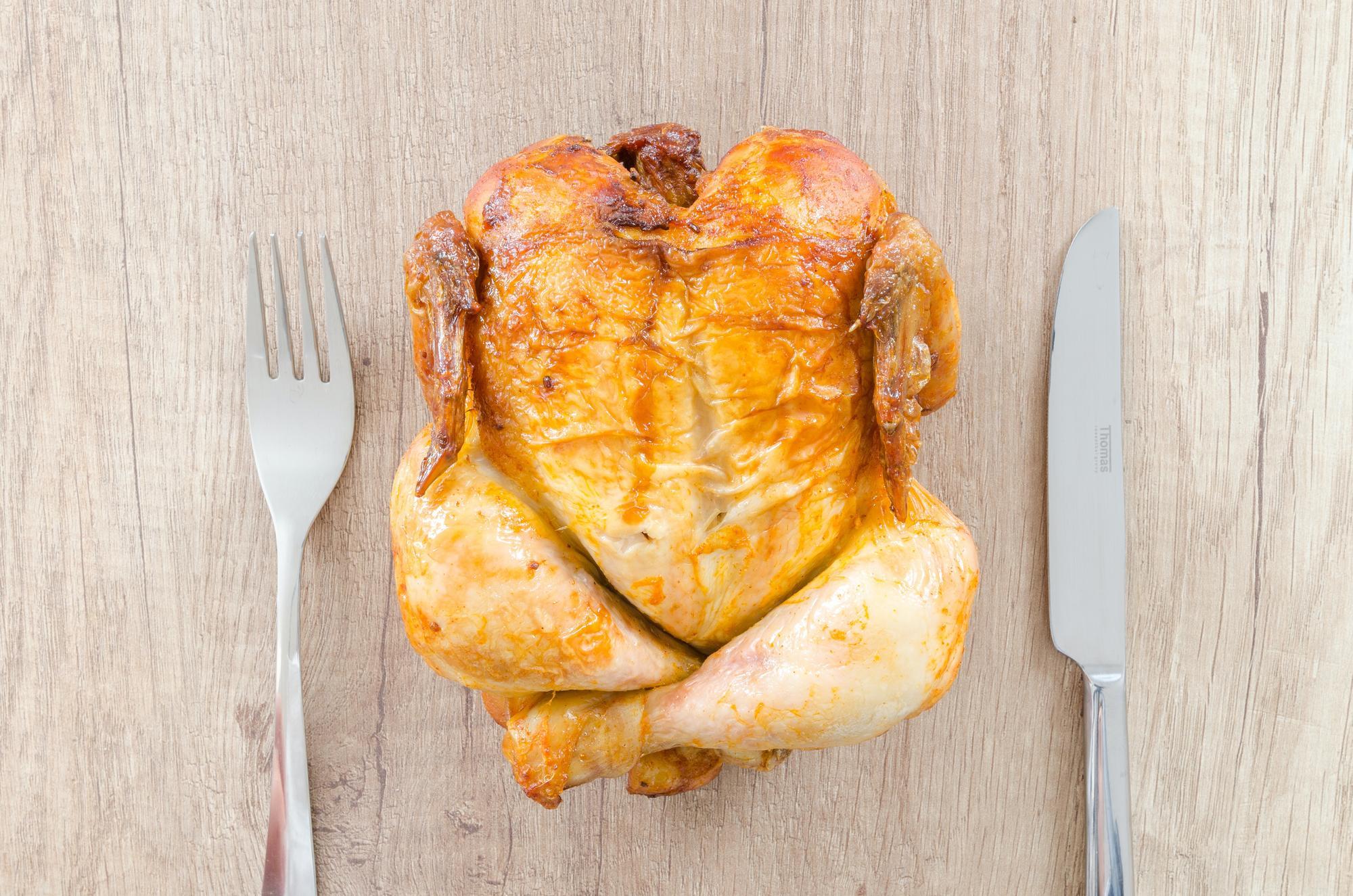 Roast chicken with a fork and knife