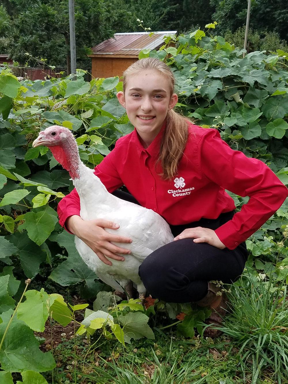 Sela Raisl poses with her 2019 Grand Champion turkey market pen.