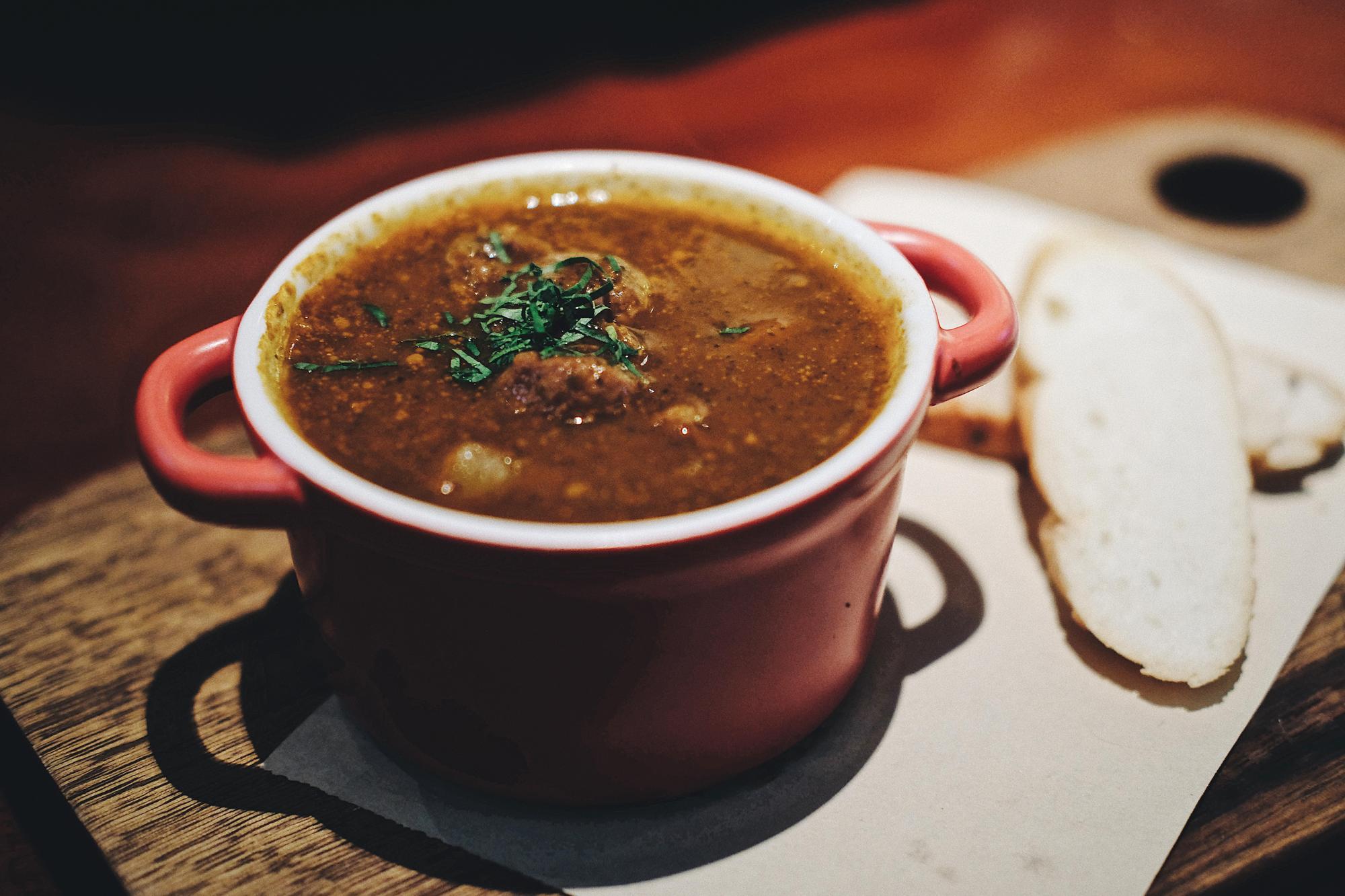 A bowl of soup with a slice of bread alongside.