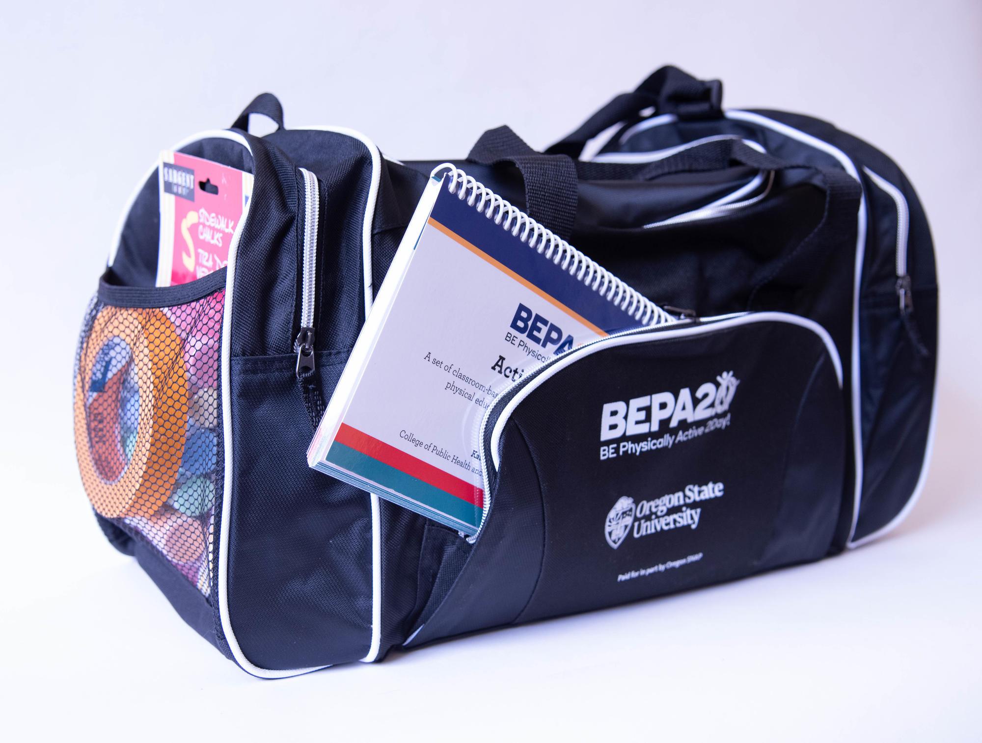 Black BEPA 2.0 duffle bag with book, tape, and chalk in the pockets