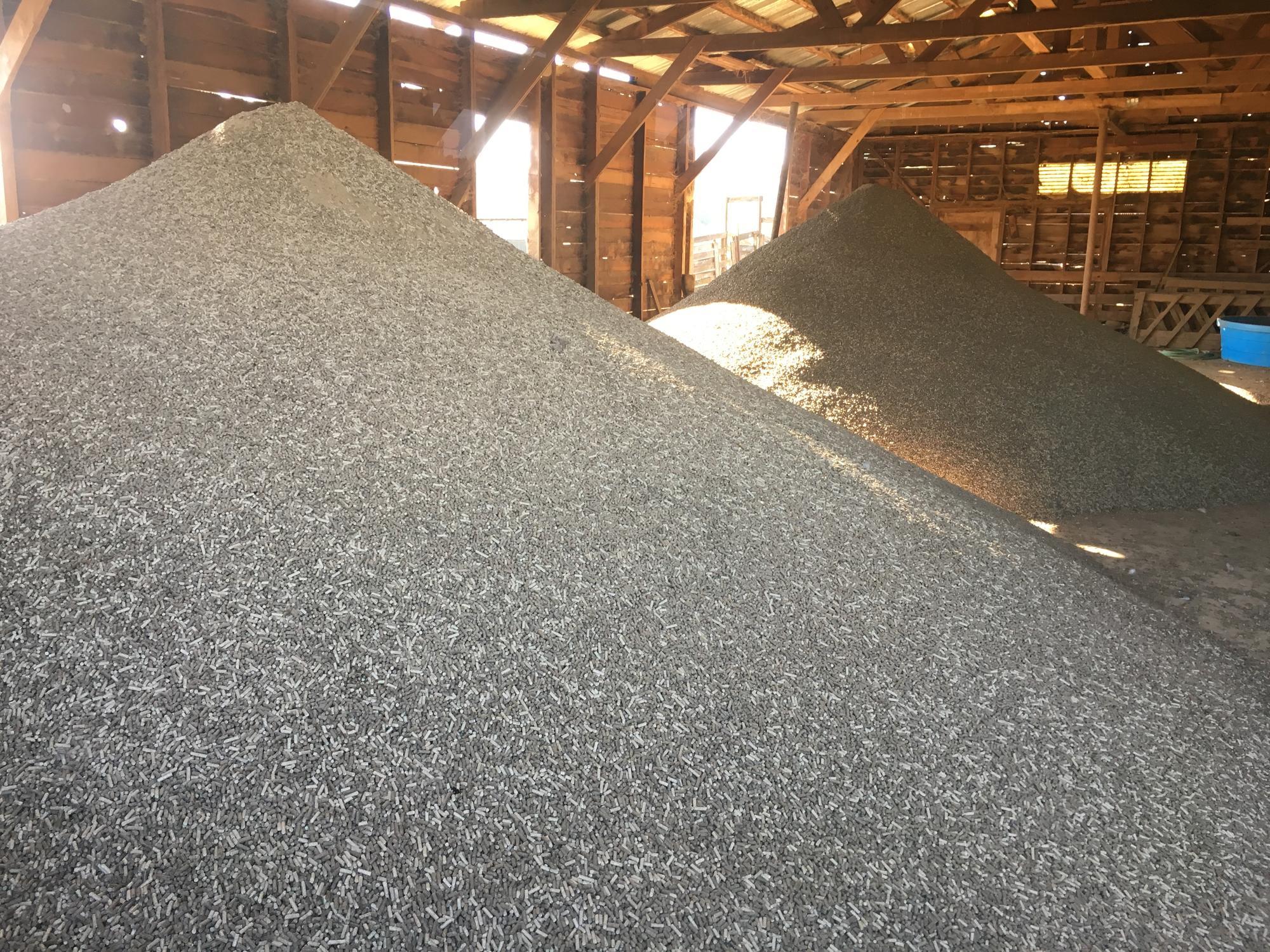 Grass seed pellet pile in a barn.