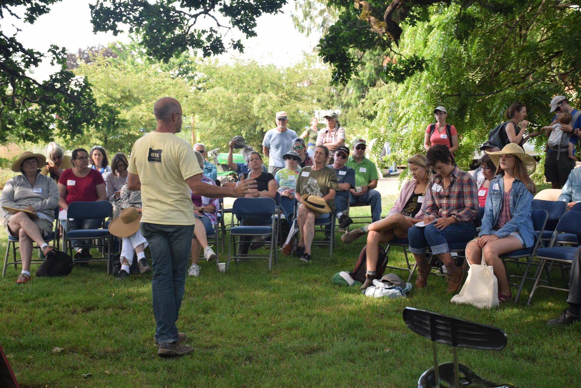Michael O’Loughlin talks about the role of beneficial insects to a group that is gathered outside on the family grass