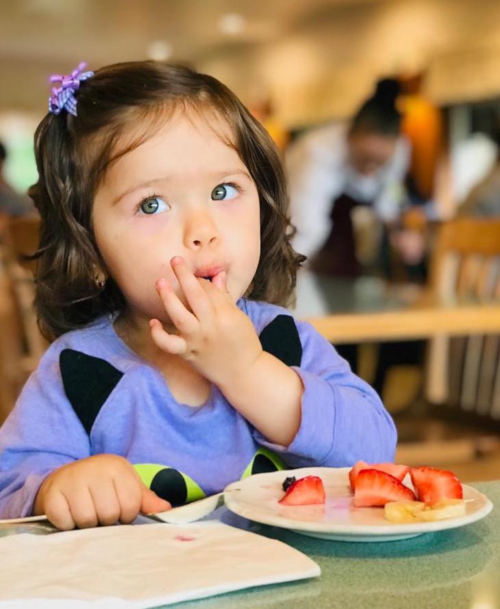 girl eating berries, licking fingers