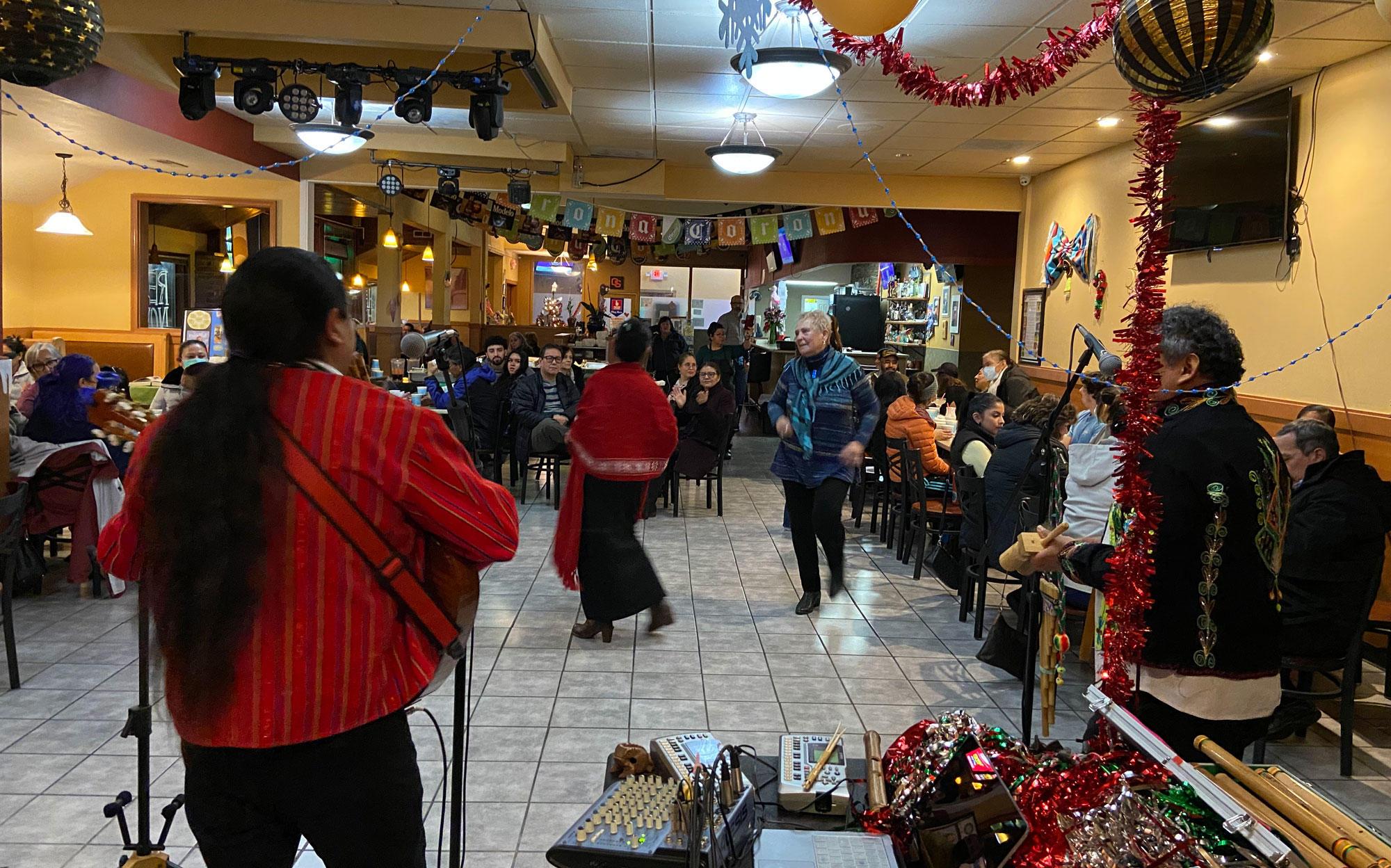 Latino women are on the dance floor as a band plays in a Mexican food restaurant.