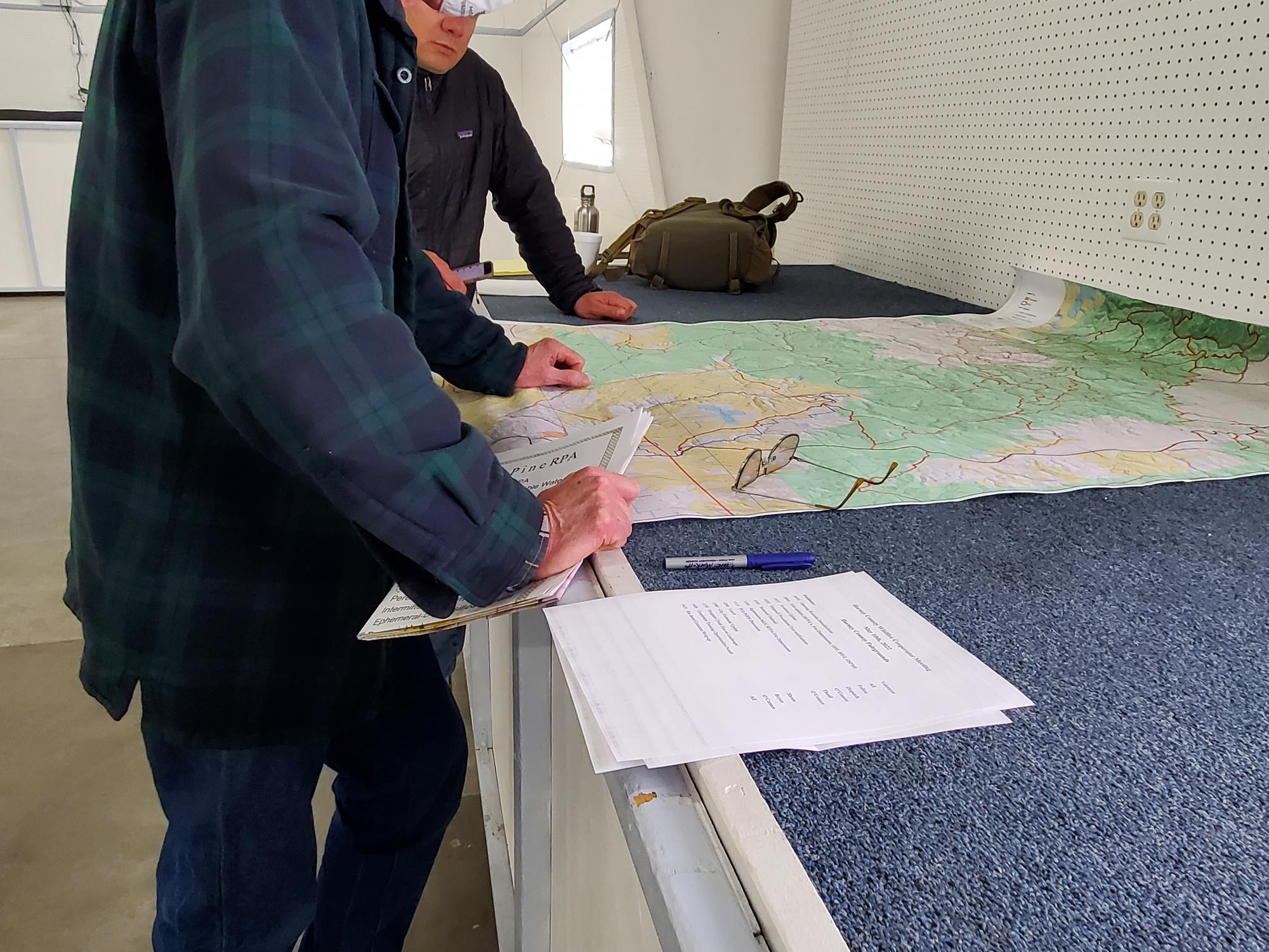 A landowner and agency staff discuss priorities for fuel treatments in an area.