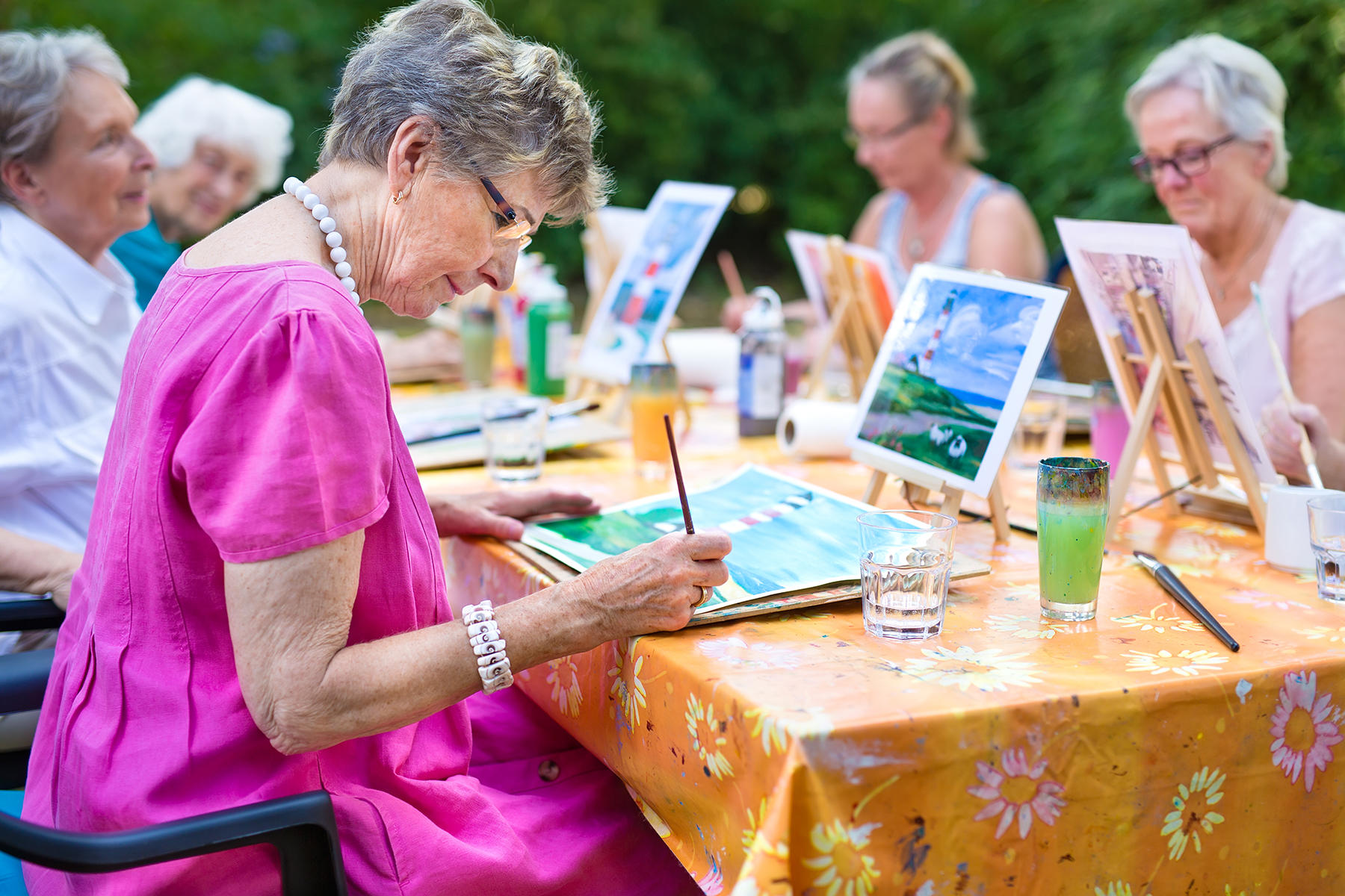 Older woman painting with her friends