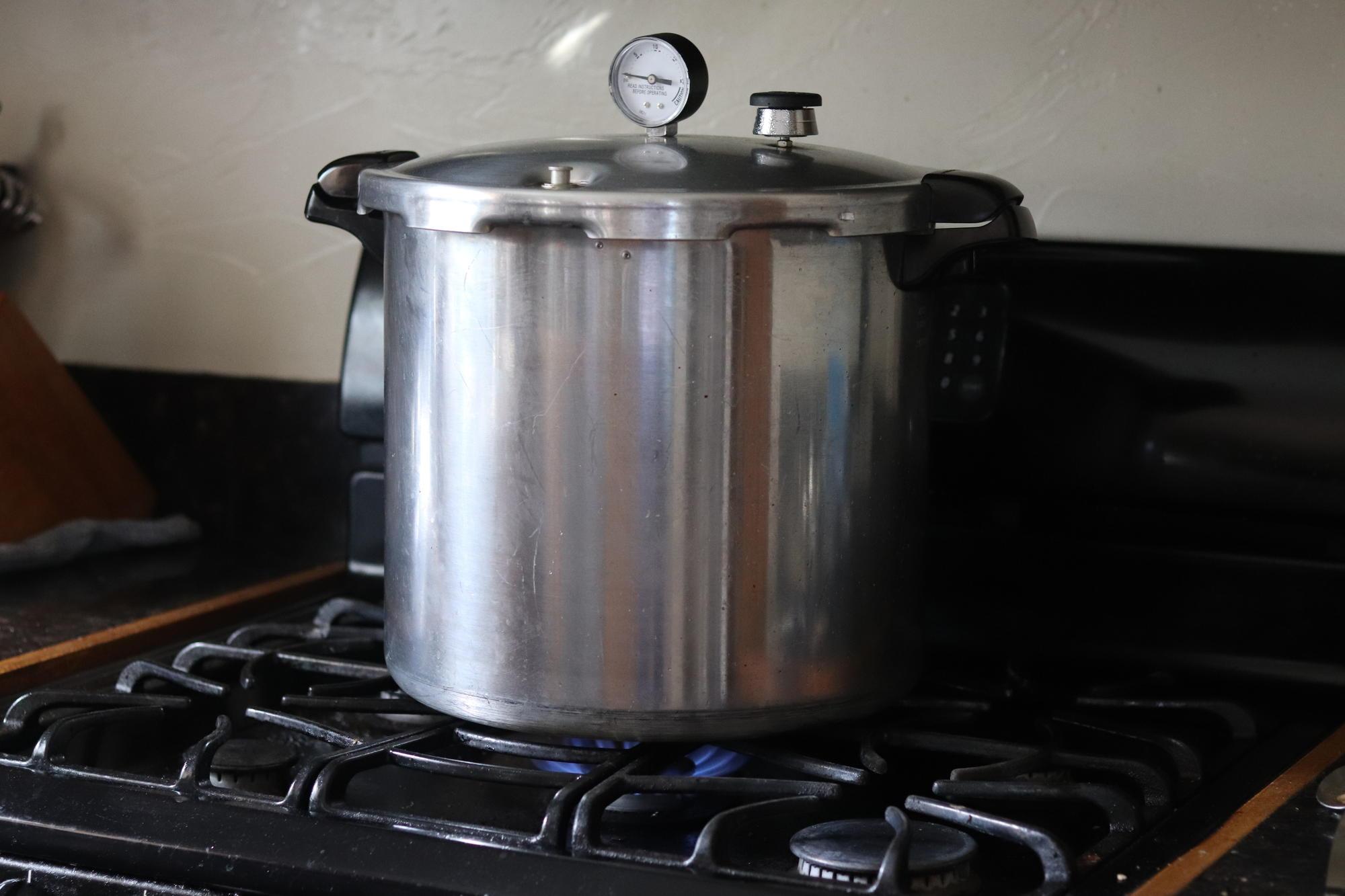 A pressure canner on a gas stove.