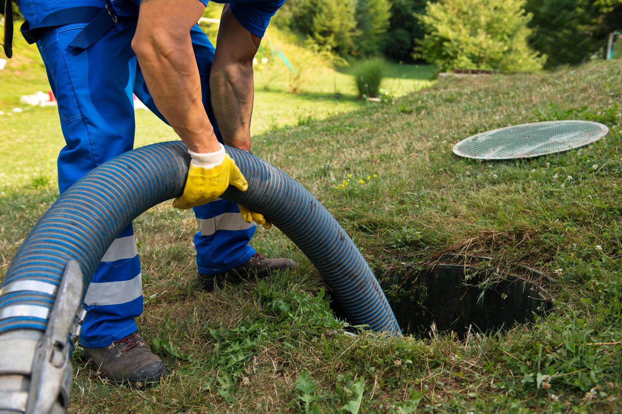 A worker pumping a septic tank.