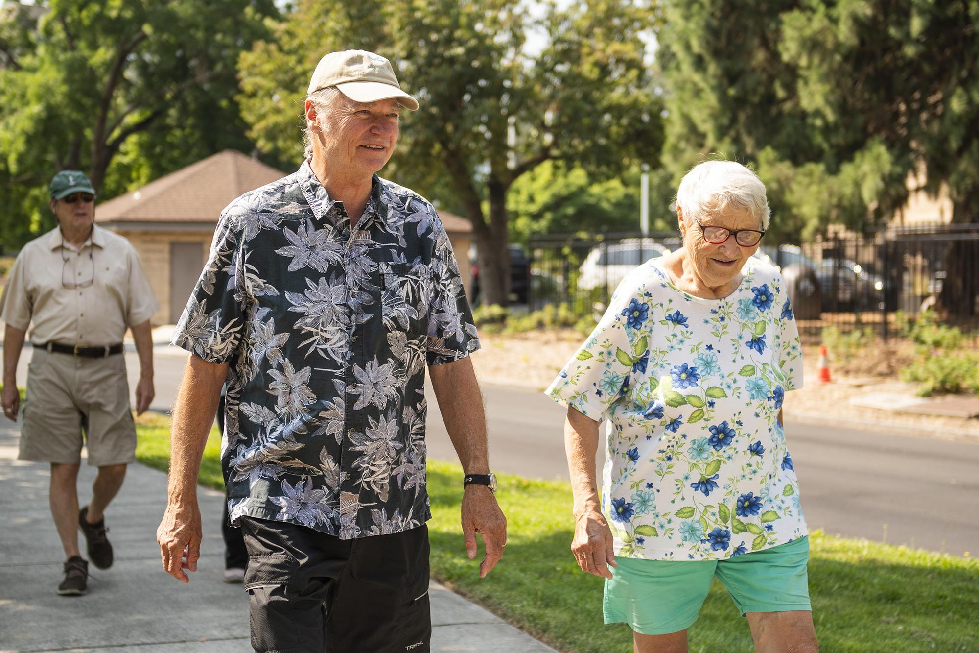 Two older people walking outside with Walk with Ease program.
