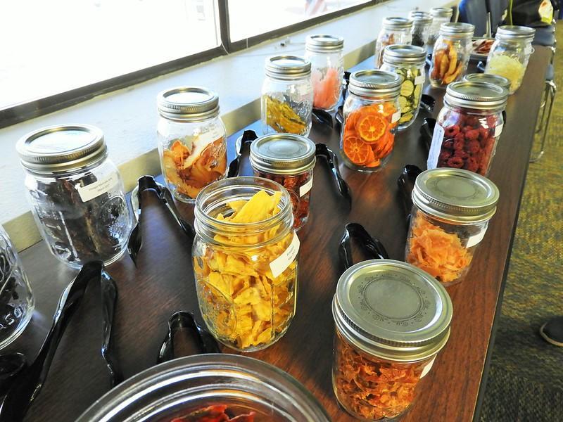 Glass jars on a tabletop full of dried fruits and vegetables