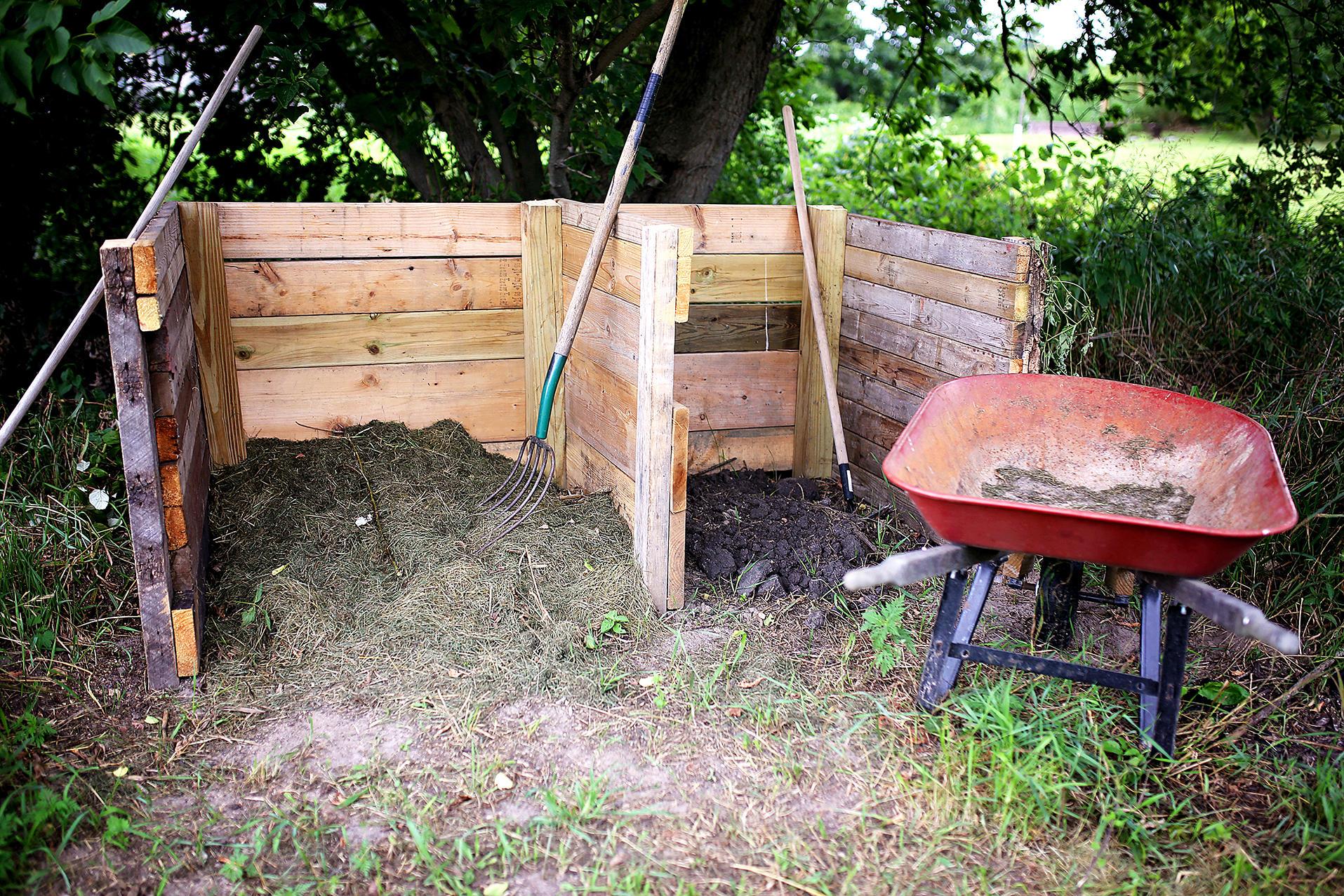 wooden compost bin with wheelbarrow