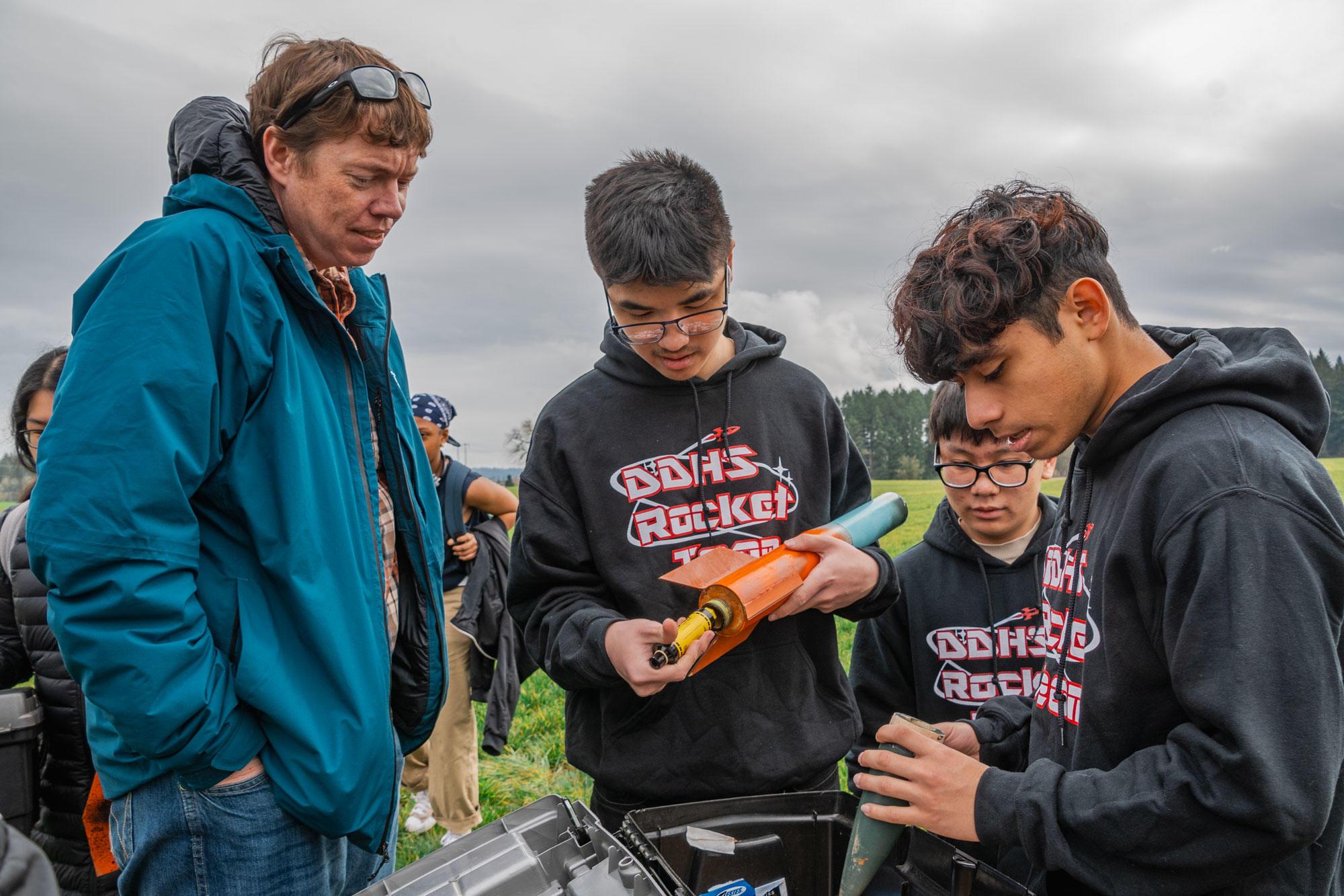 Members of the David Douglas High School Rocket Club, which is affiliated with OSU Extension 4-H, look at a rocket post-flight.