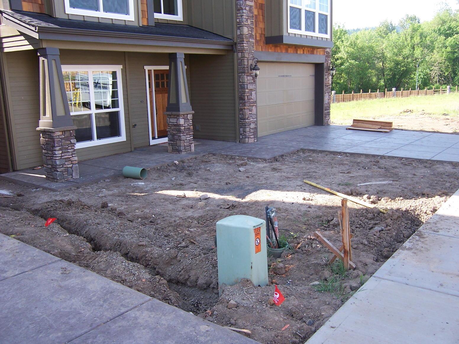 front dirt landscape new construction house background encircled by cement walk and driveway