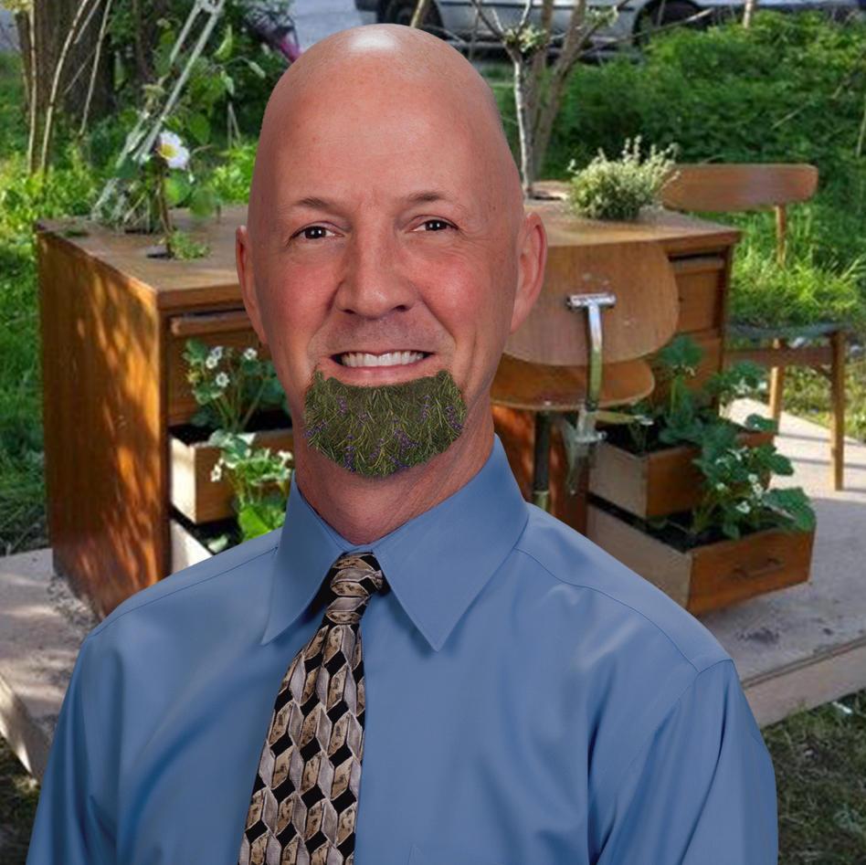 smiling man wearing blue shirt and patterned tie in a gardening and school desk atmosphere
