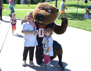 Benny, Oregon State University's mascot, poses with two children at Benny Bash.
