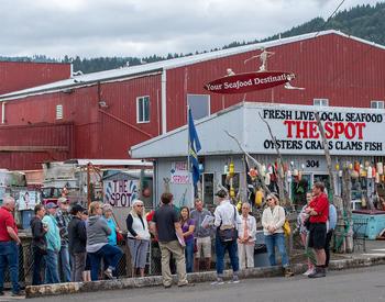 A group of people gathers at the Port of Garibaldi for a Shop at the Dock tour