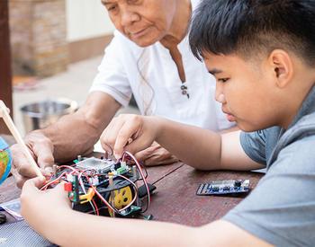 Grandfather and grandson work together on an electronics project