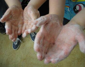 Two sets of hands with soapy lather