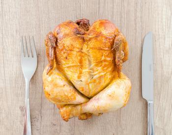 Roast chicken with a fork and knife