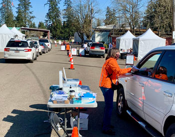 Jan Williams, with the OSU Extension Service in Clackamas County, collects paperwork from participants before they receive their shot at the drive-through COVID-19 vaccination clinic on March 31 in Canby.
