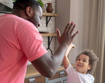 young girl high-fives father figure