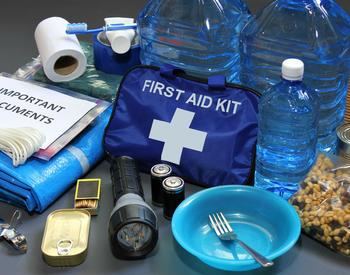 Various emergency supplies including bottled water, shelf-stable food, toilet paper, a flashlight, a first-aid kit, batteries, important documents, and more.