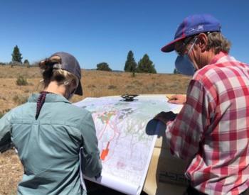 A landowner and a U.S. Fish and Wildlife Service staff member discuss the location of fuel breaks within the area.