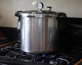 A pressure canner on a gas stove.