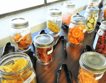 mason jars of various dried fruits and vegetables sit on table