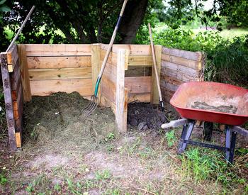 wooden compost bin with wheelbarrow