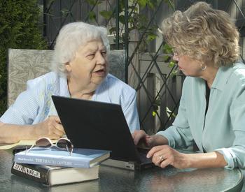 Two women, one who is a senior, discussing at a laptop