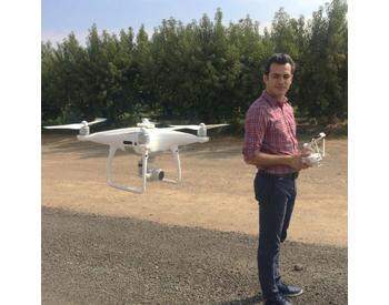 Dr. Alireza Pourreza operates a drone in a California orchard.